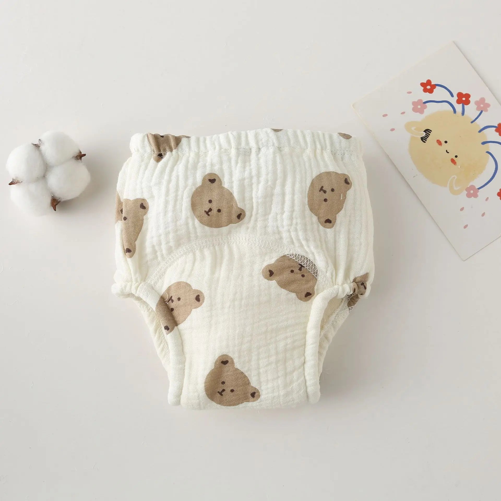 Cotton baby training diaper featuring a cute brown bear pattern on a white background. Soft baby care essential.