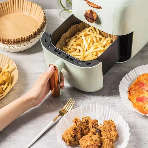 Round air fryer paper liner set on counter with fries