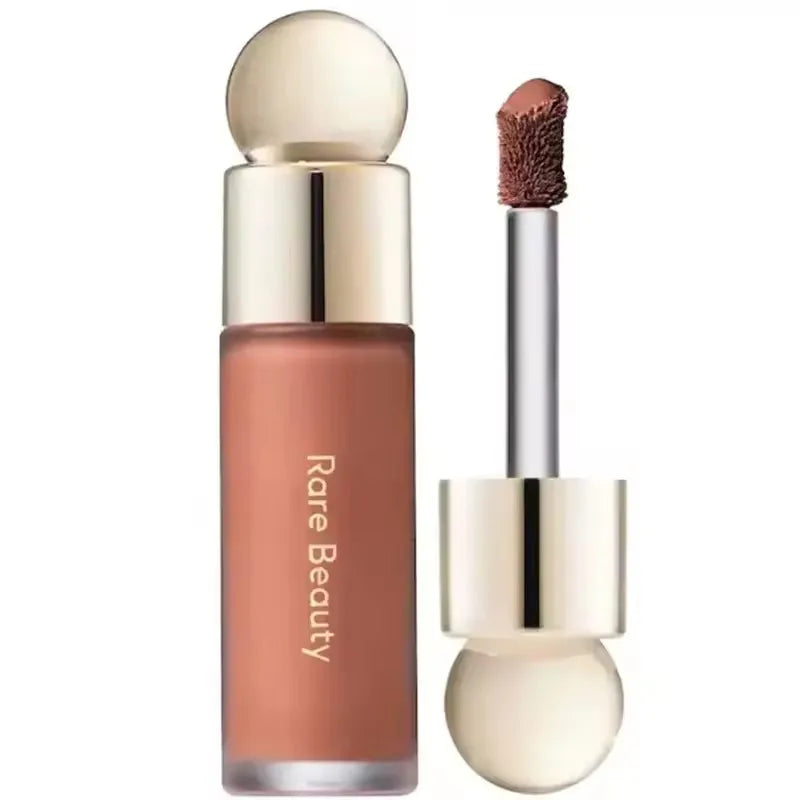 Rare Beauty matte lipstick in rich nude shade with smooth applicator and elegant gold cap. Moisturizing lip makeup.