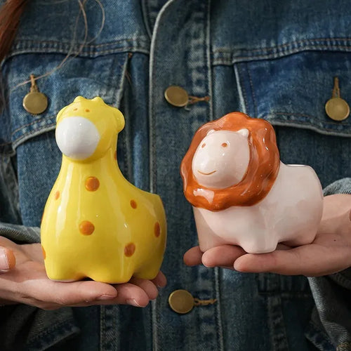 Yellow and orange animal-shaped ceramic flower pots held in hands