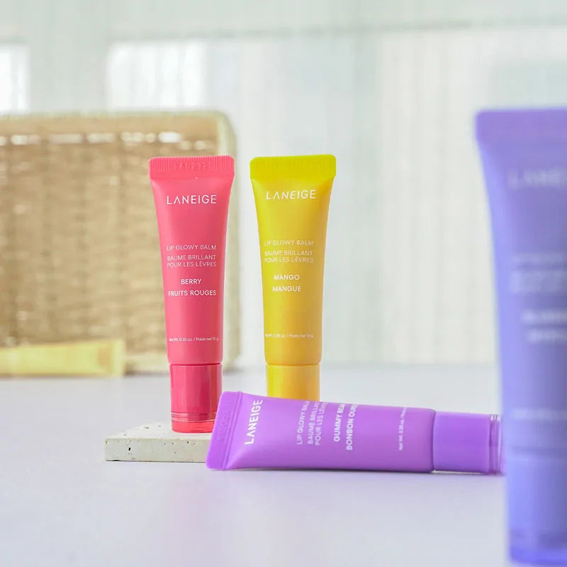 Laneige Lip Glowy Balm set in Berry, Mango, and Gummy Bear scents. Colorful moisturizing lip gloss tubes for treatment.