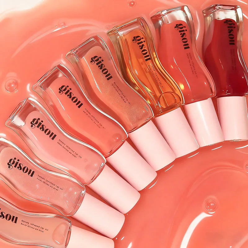 Gisou Lip Oil collection in various shades, from clear to glazed plum, with glossy, hydrating, plumping oil textures.