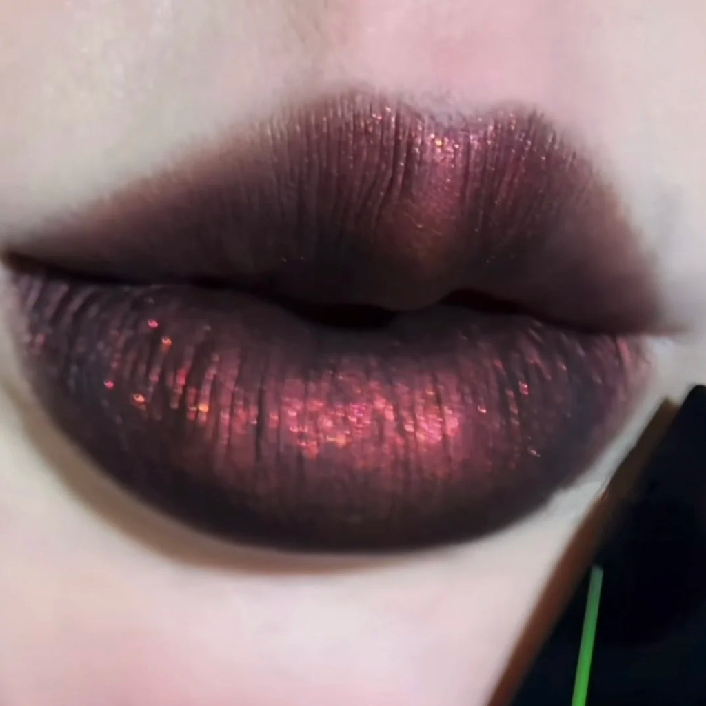 DE'LANCI gothic dark red shimmer lip mud with a smoky, high-pigment matte finish and subtle glittery texture.