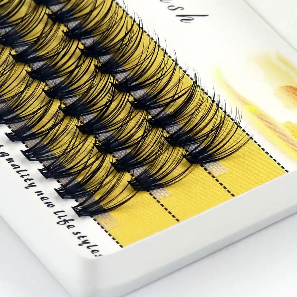 Black 3D mink individual eyelash clusters in a tray, arranged for natural volume extensions.