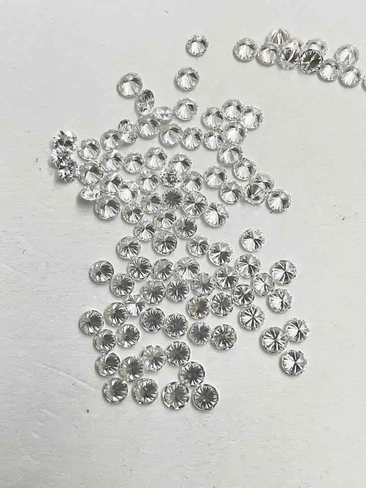 Loose round brilliant diamonds, clear white sparkle stones scattered on a surface