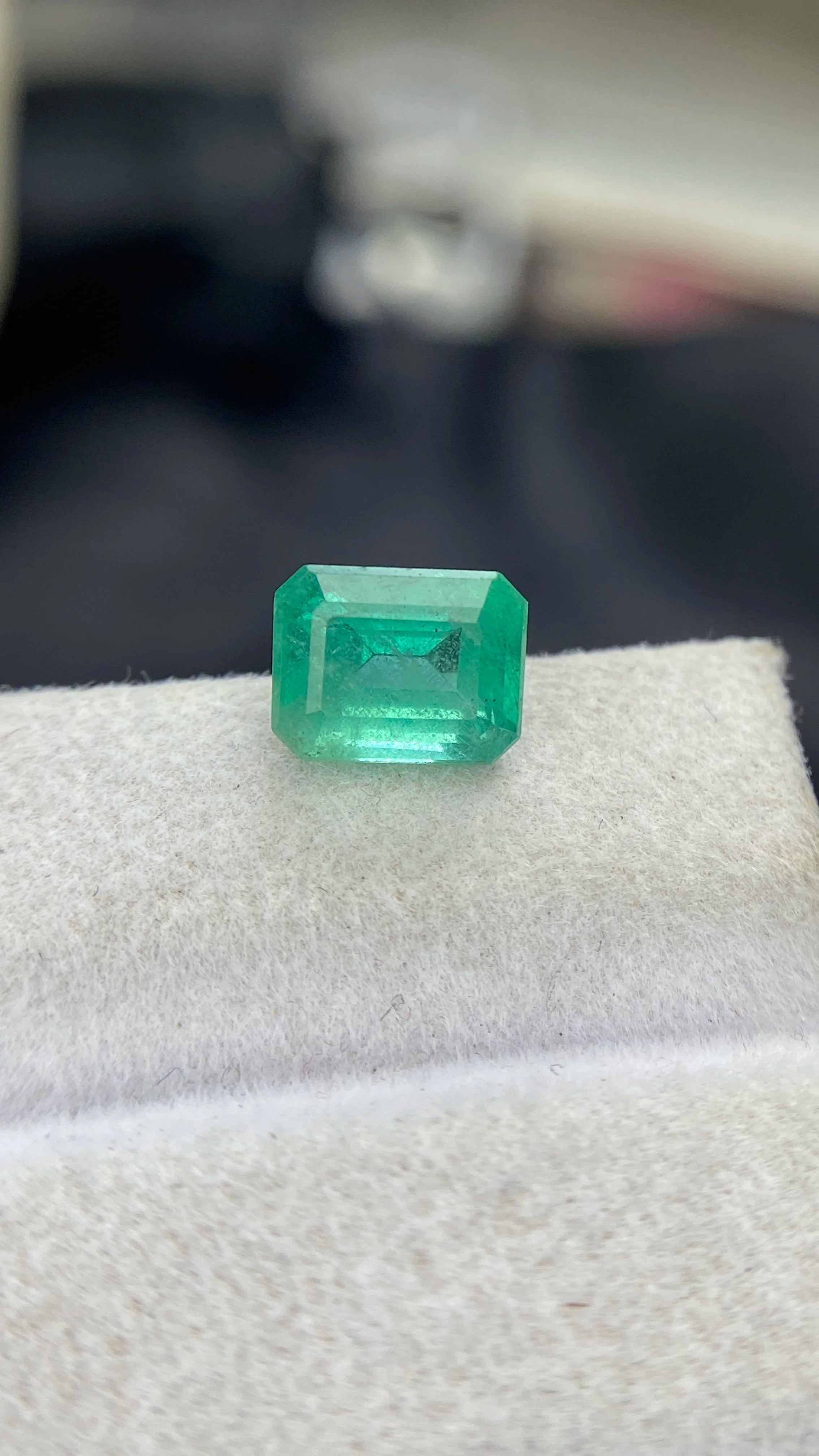 Loose emerald-cut green gemstone with faceted edges