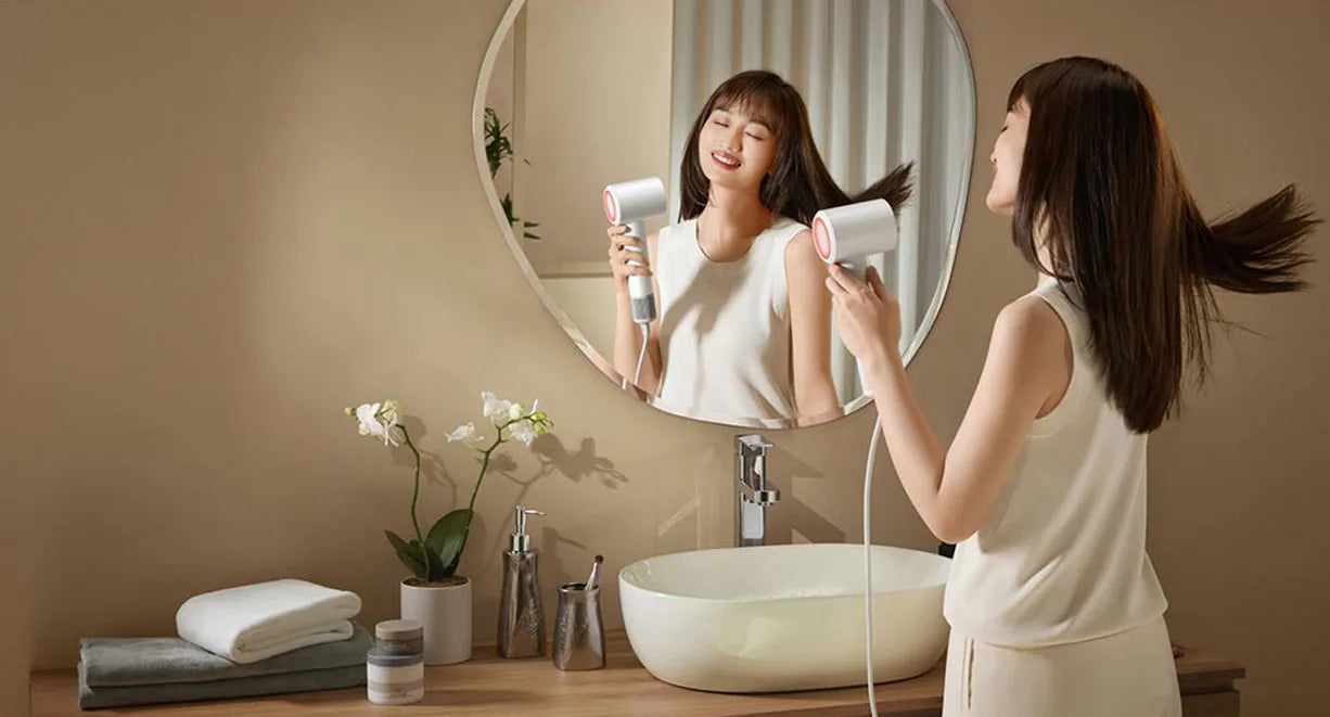 Woman using a white MIJIA H501 SE high-speed ionic hair dryer for professional salon-quality drying in a modern bathroom.