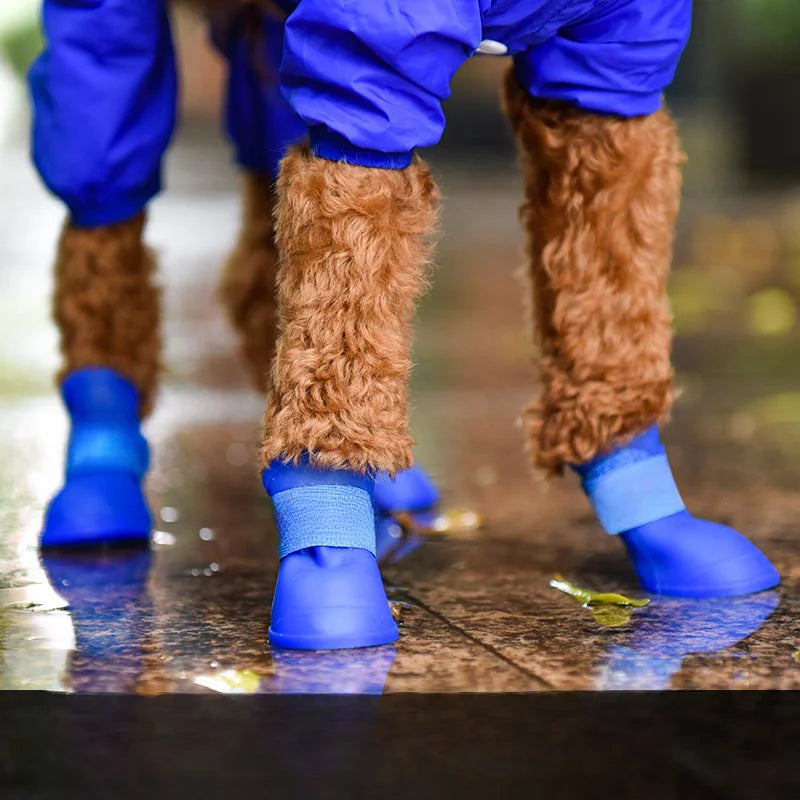 Blue waterproof non-slip dog rain boots protecting a pet's paws while walking on wet outdoor surfaces.