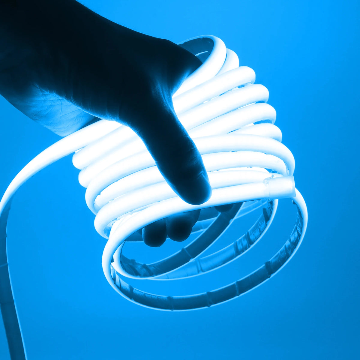 Waterproof COB LED neon strip light glowing blue, held in hand