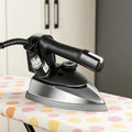 Steam iron for clothes on a polka-dot ironing board, with black handle, temperature dial, and stainless steel soleplate.