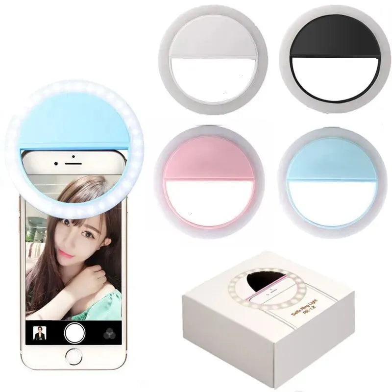 Clip-on circular LED selfie ring lights in white, black, pink, and blue, designed to attach to smartphones for lighting.