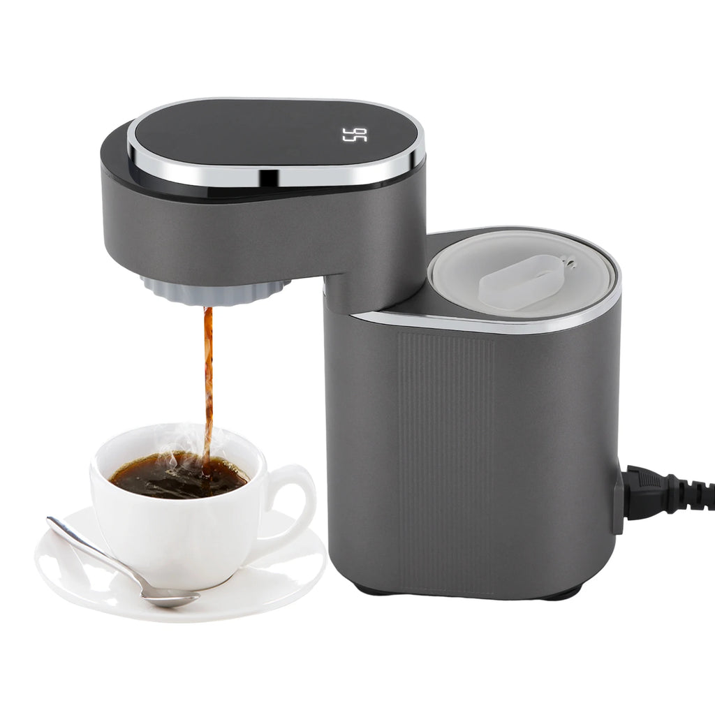 Modern dark grey single-serve coffee maker with digital temperature display pouring coffee into a white cup.