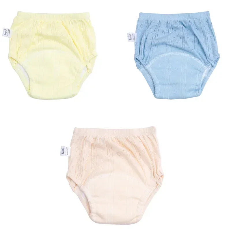 Three-pack of U&U baby training diaper underwear in pastel yellow, blue, and cream cotton with eyelet texture.