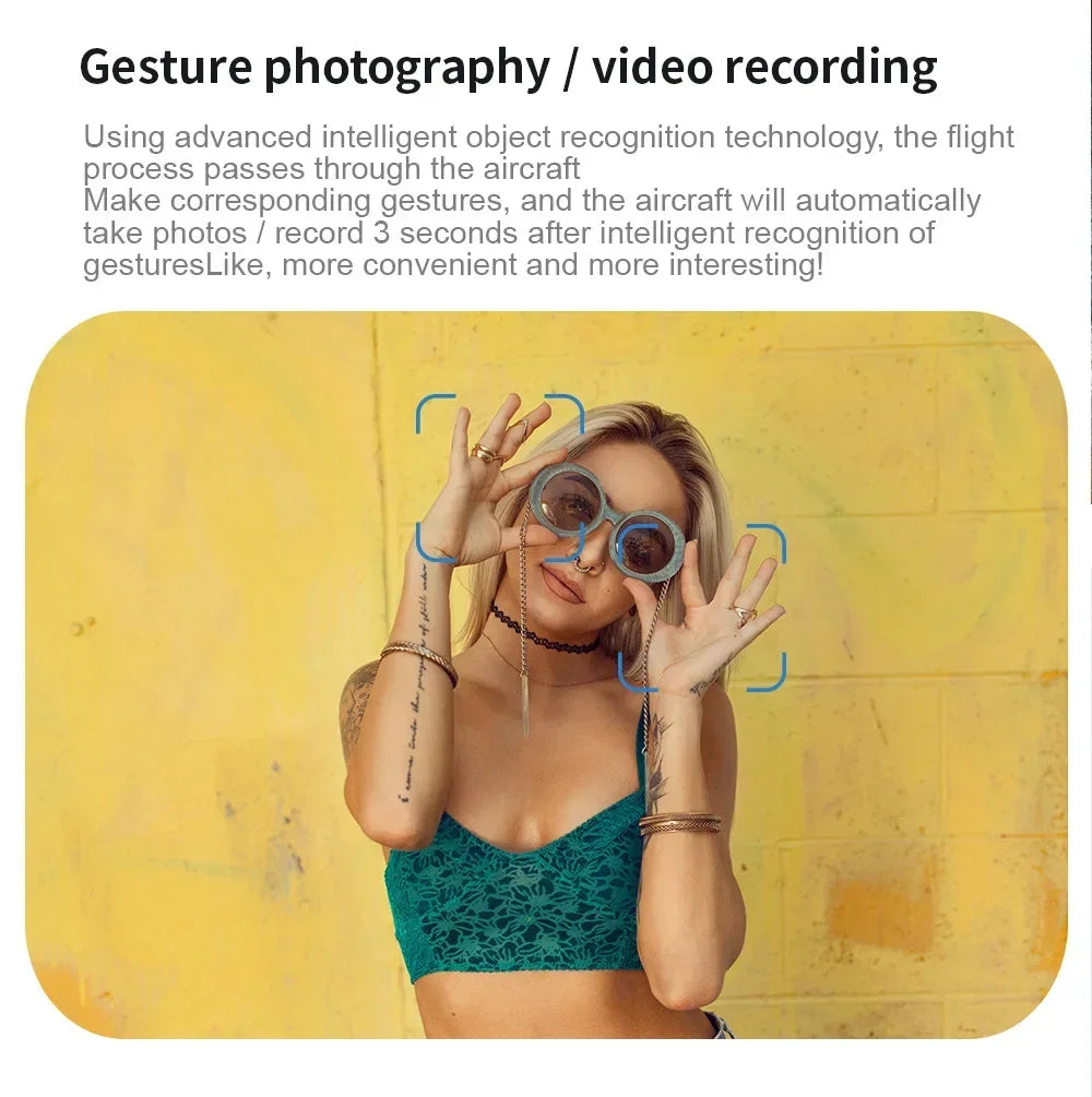 A woman in a green lace top holding round, grey-rimmed glasses, demonstrating gesture-controlled photography.