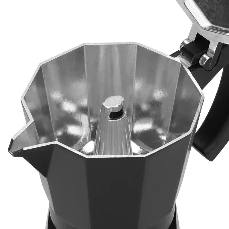 Inside view of a black aluminum stovetop moka pot coffee maker showing the metallic chamber and central column.