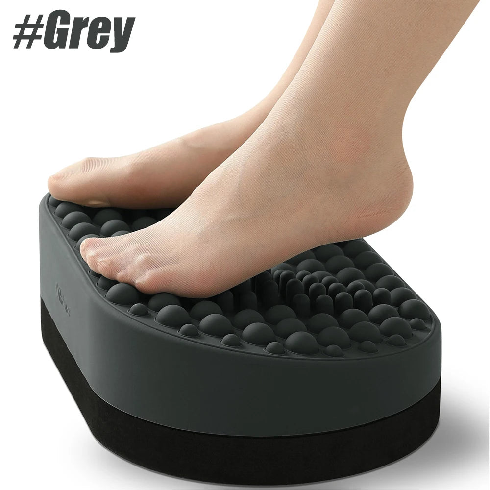 Grey ergonomic under-desk foot rest stool with soft silicone massage bumps for plantar fasciitis relief.