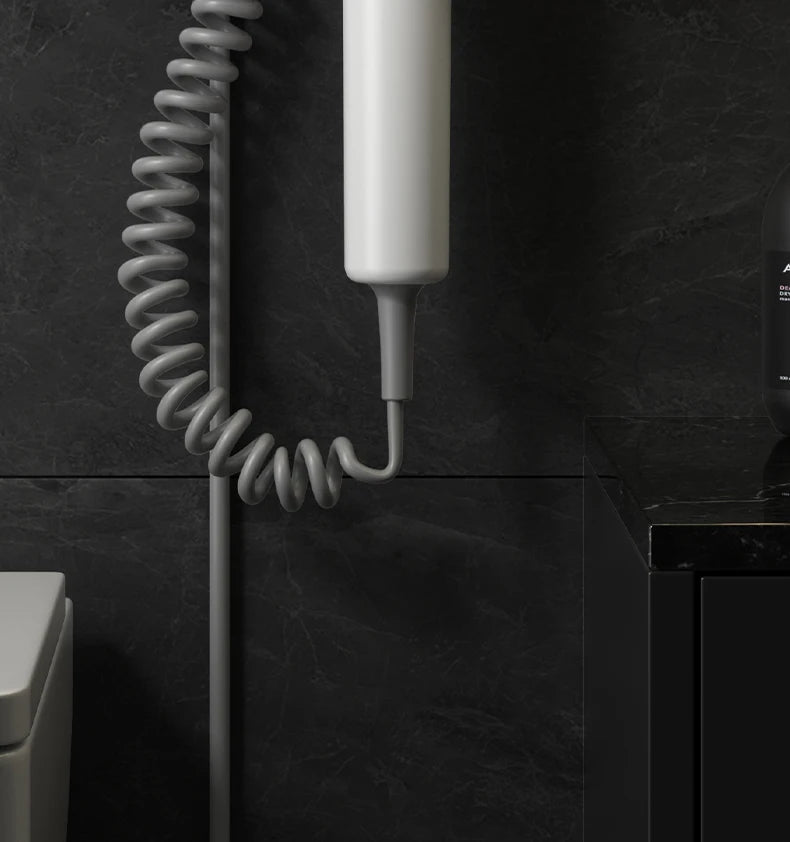 White wall-mounted hotel hair dryer with coiled cord for home bathrooms, featuring blue light hair care technology.