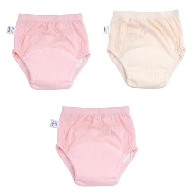 Three-pack Uou baby training diaper underwear in pink and cream, soft absorbent cotton for toddler potty training.