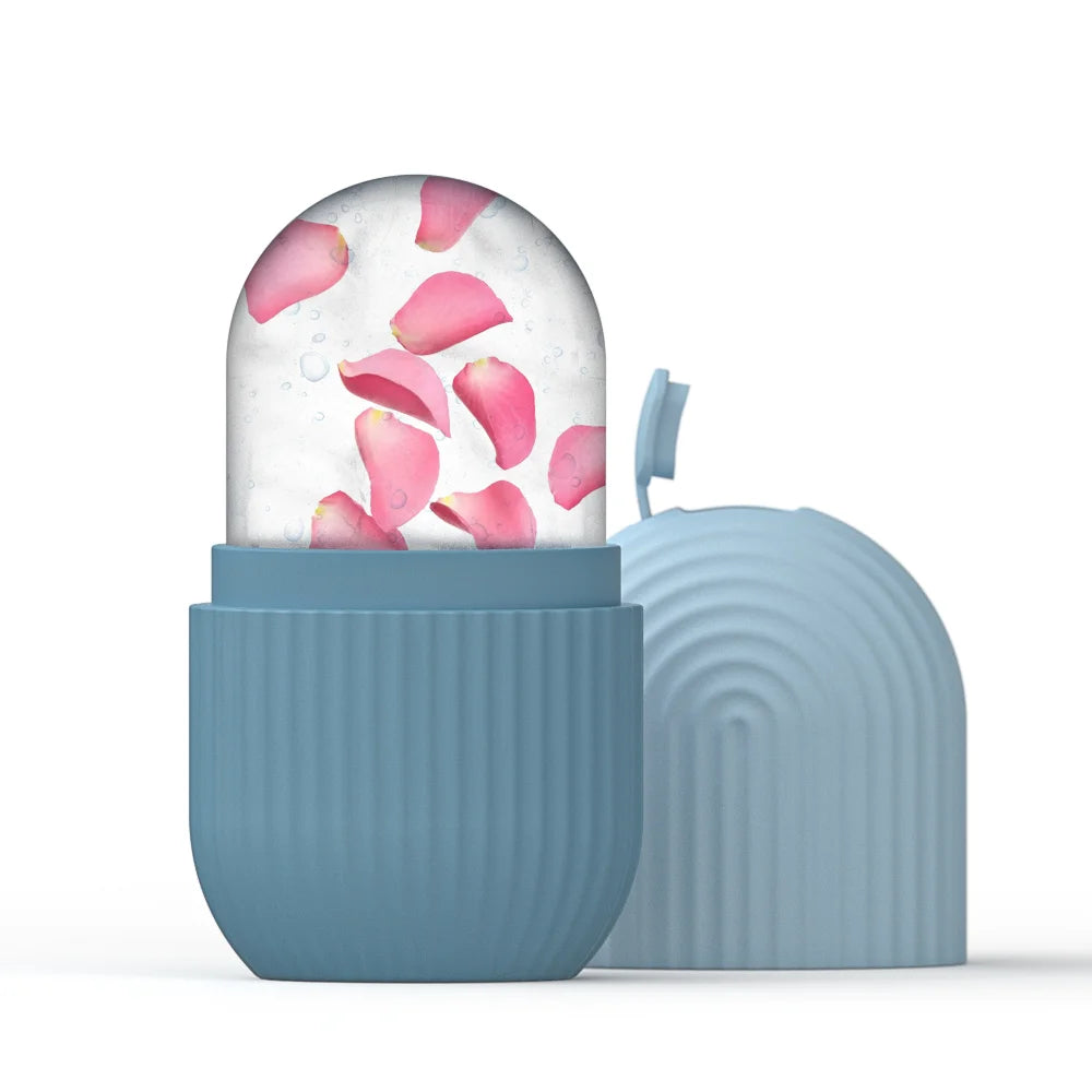 Blue silicone ice roller mold with a dome of frozen water containing pink rose petals, beside its matching cap.