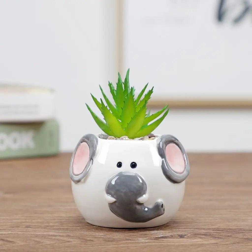 White animal-face ceramic planter with gray snout and small green succulent plant