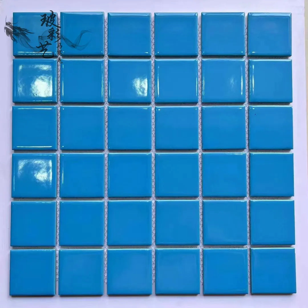 Ceramic mosaic tile sheet with glossy square blue tiles on a grid backing