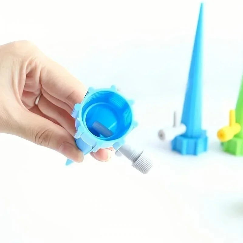 Blue drip irrigation nozzle valve with removable cap, held by a hand