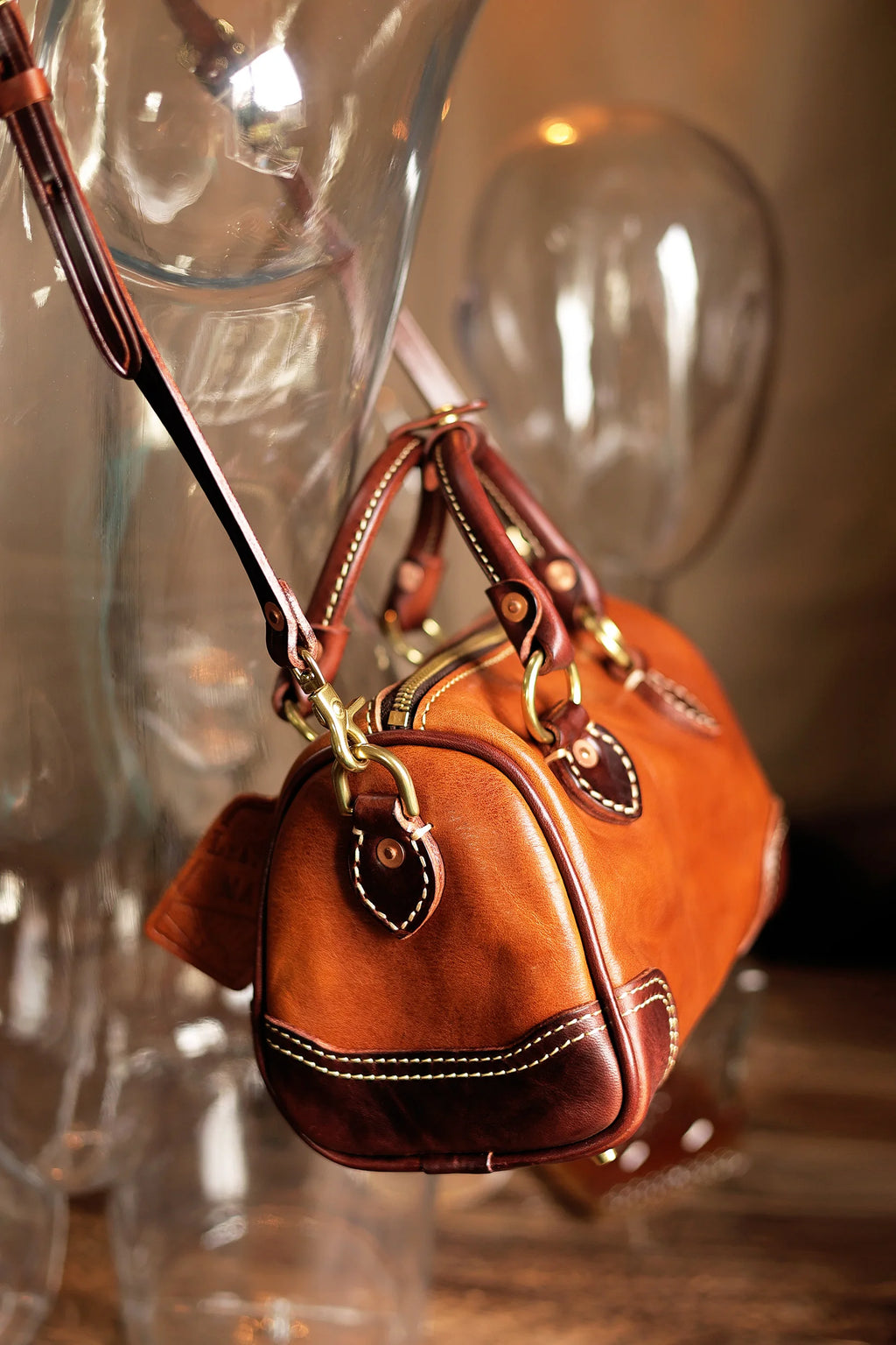 Vintage brown genuine cowhide leather designer handbag, small barrel shape with contrast stitching and gold hardware.