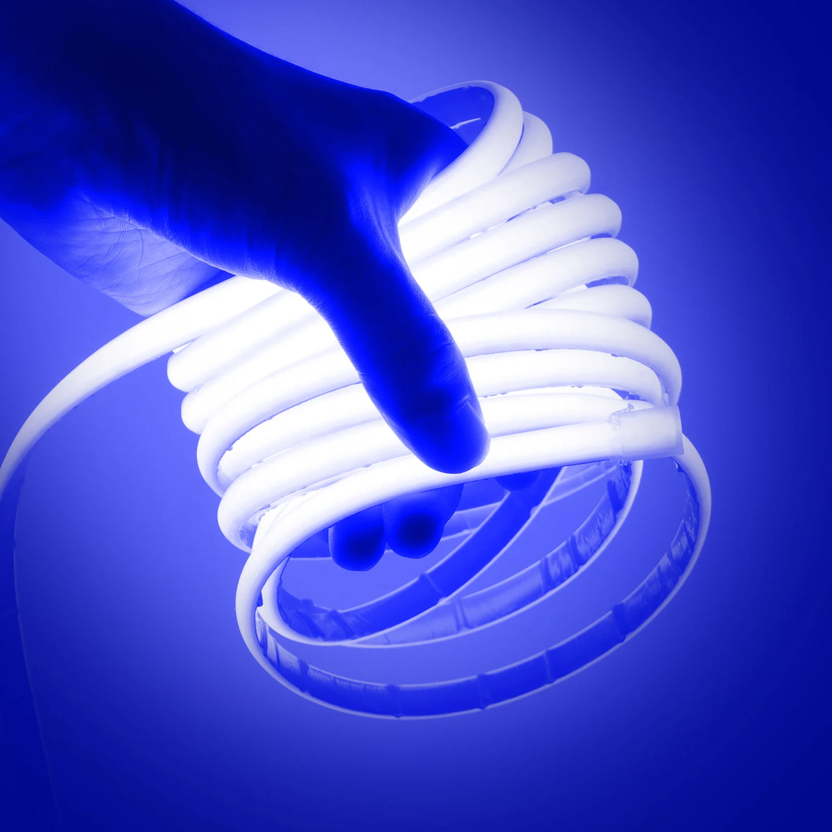 Waterproof COB LED neon strip light glowing ice blue, held in hand