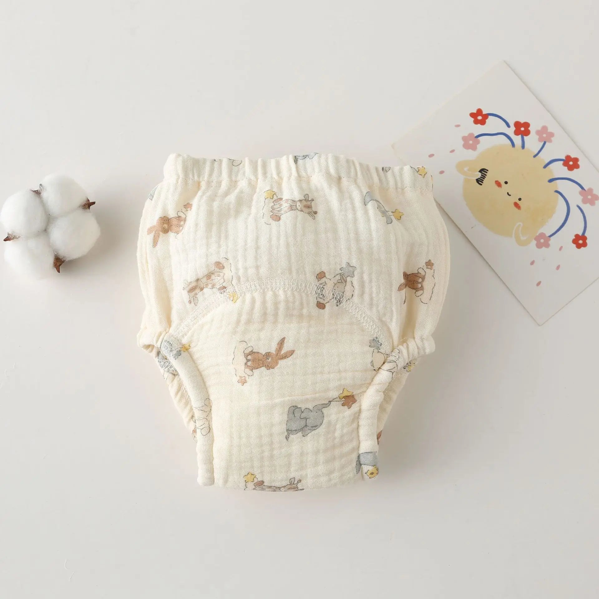 Baby care absorbent cotton muslin training diaper with cute bunny and elephant print on cream fabric.