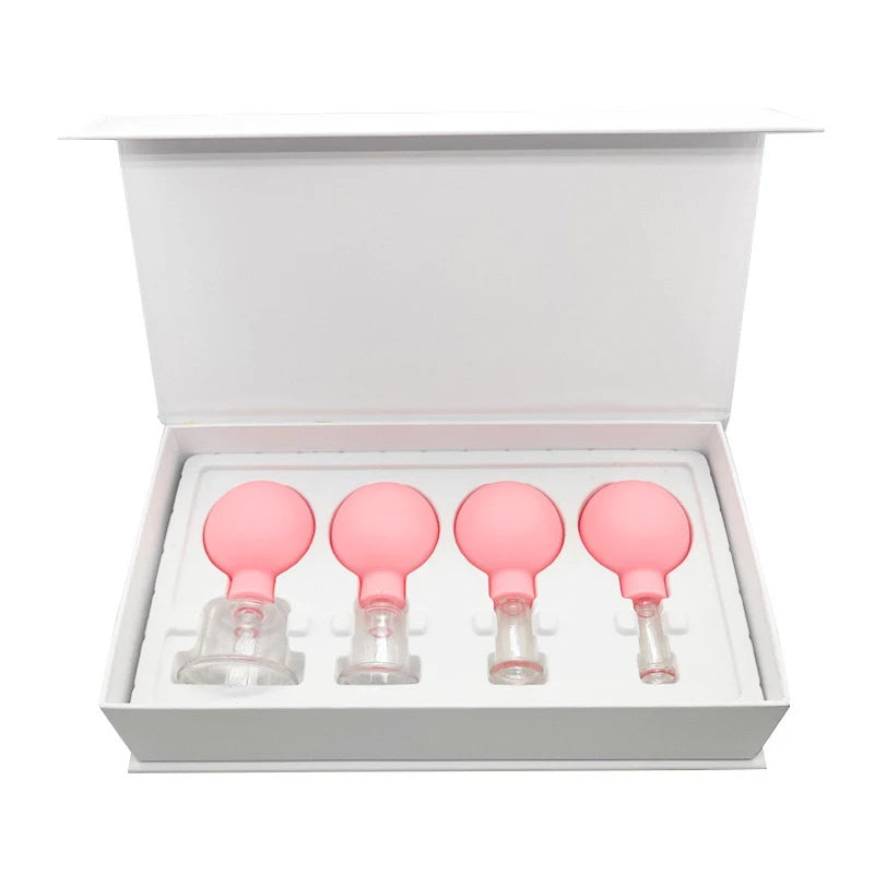 Four pink rubber and glass facial cupping tools of varying sizes displayed in a white gift box.