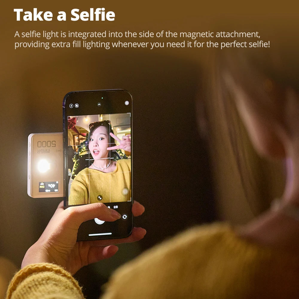 White rectangular magnetic phone power bank with an integrated LED selfie light attached to the back of a smartphone.