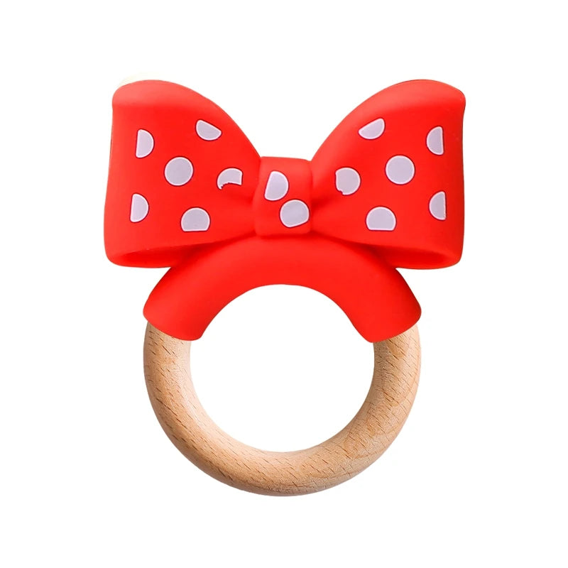 Red polka dot bow silicone and natural wood baby teething ring for soothing infant teething pain.