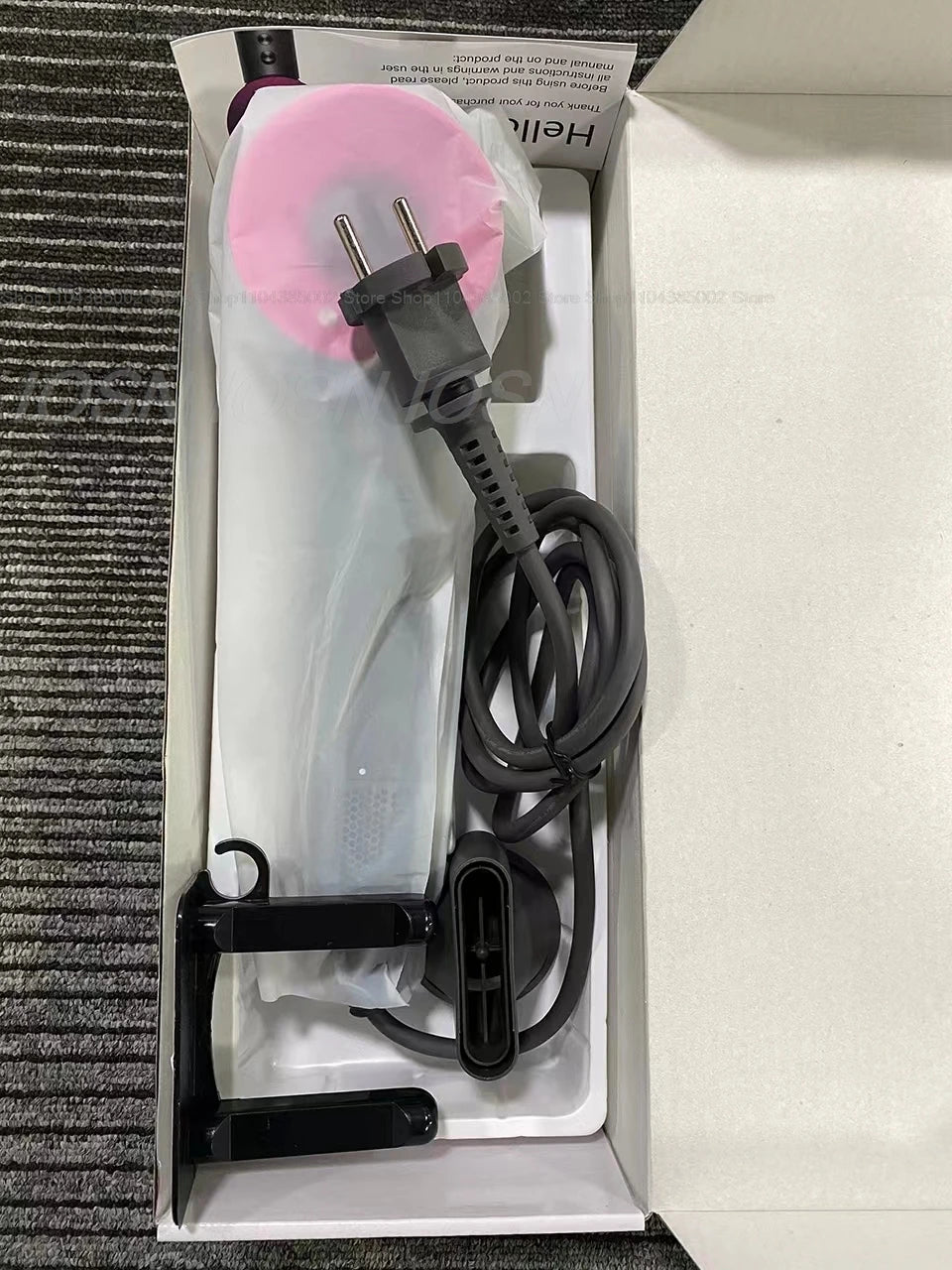 Professional leafless negative ion hair dryer in a box with black nozzle attachment and plug.