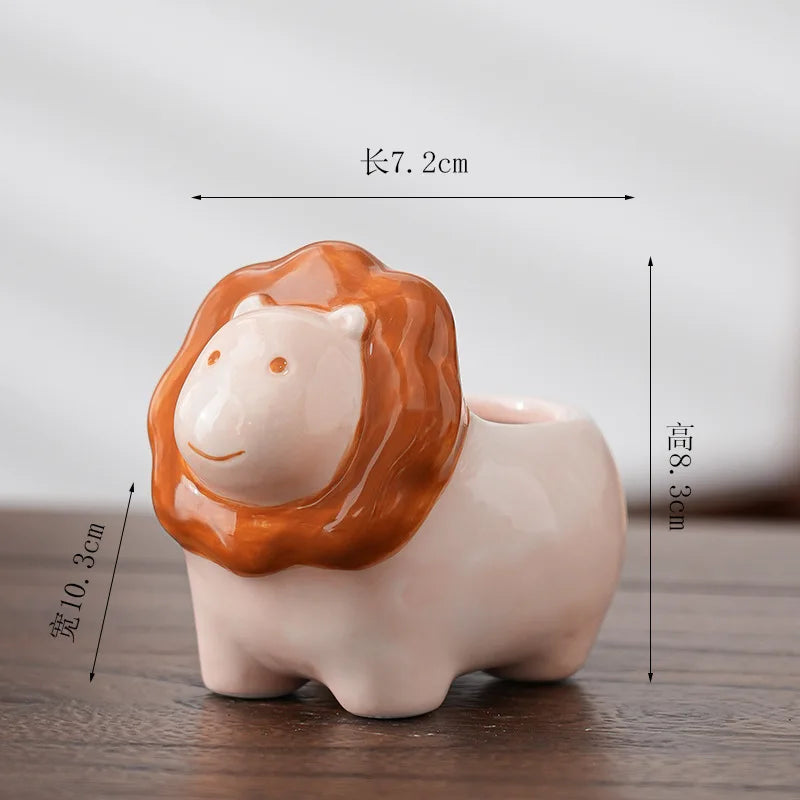 Orange animal-shaped ceramic flower pot with white face and curled mane detail
