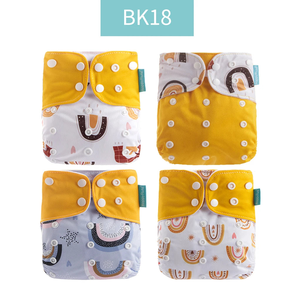 Four Happy Flute reusable cloth diapers with yellow snap covers and colorful rainbow baby prints.