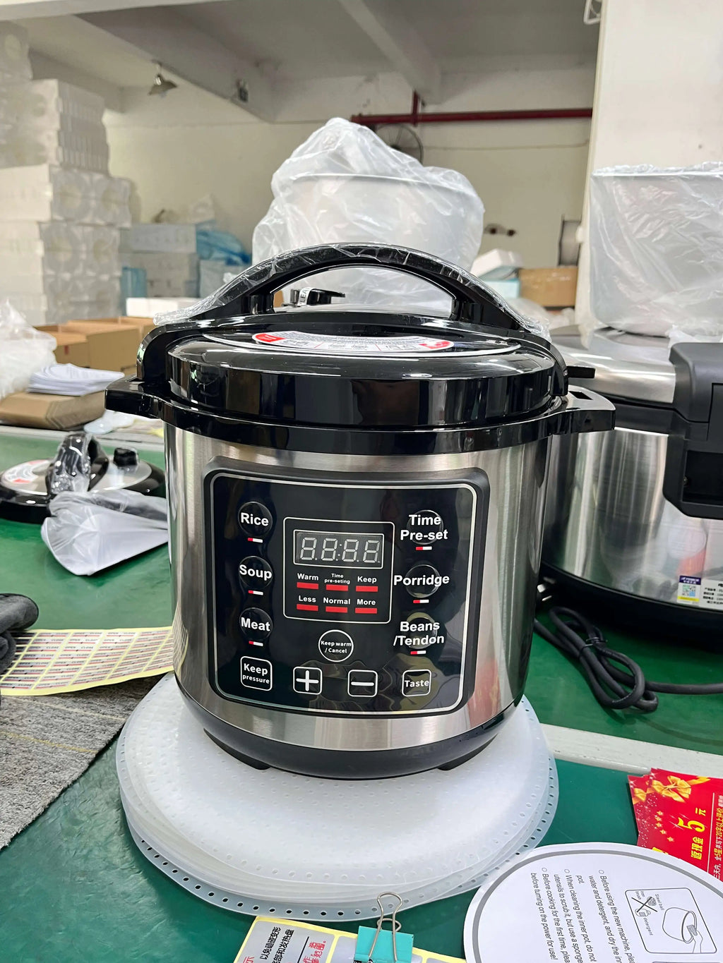 Stainless electric pressure cooker with black lid and digital control panel