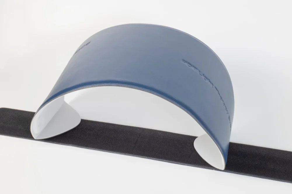 Blue, arched LED face mask device with a smooth exterior, white interior, and a long black strap on a white background.