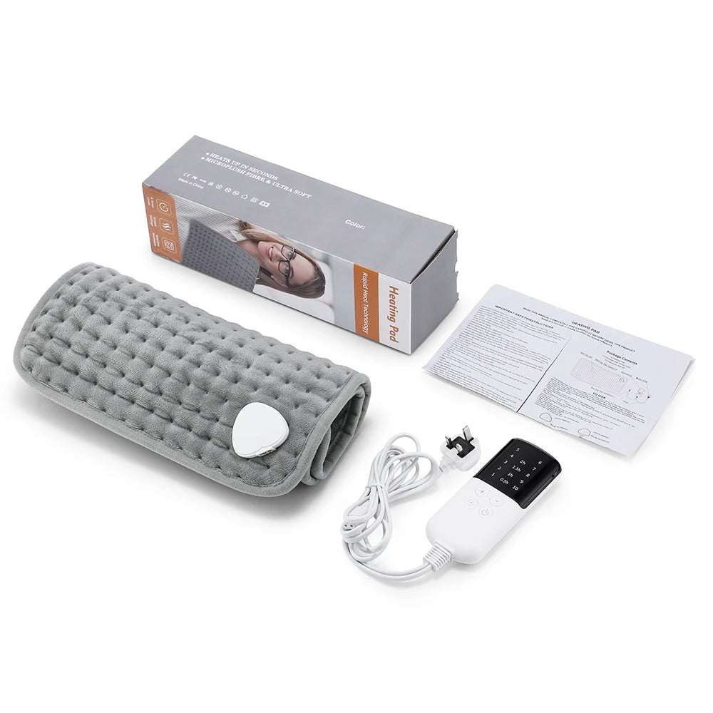 Grey quilted plush electric heating pad with digital controller, power cord, user manual, and retail box.