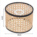 Cylindrical 16x12cm rattan lampshade with black fabric trim and a white metal spider fitter.