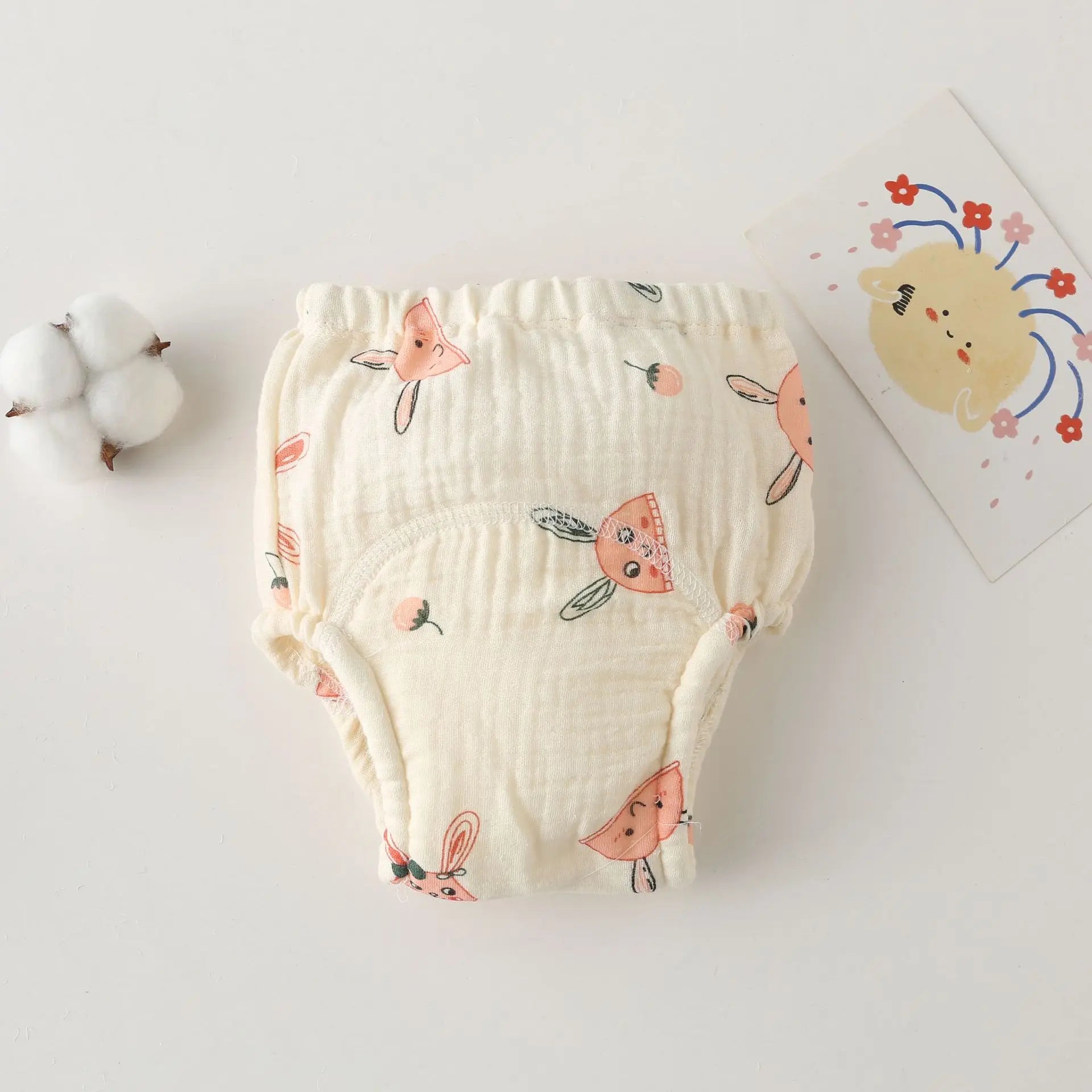 Cream cotton baby training diaper with cute bunny and strawberry print, soft breathable baby care underwear.