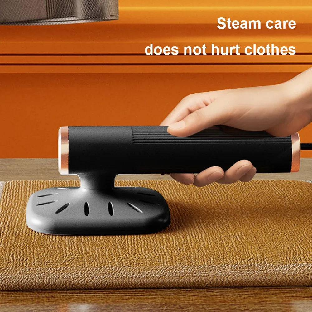 Handheld garment steamer in black with rose gold accents resting on textured fabric.