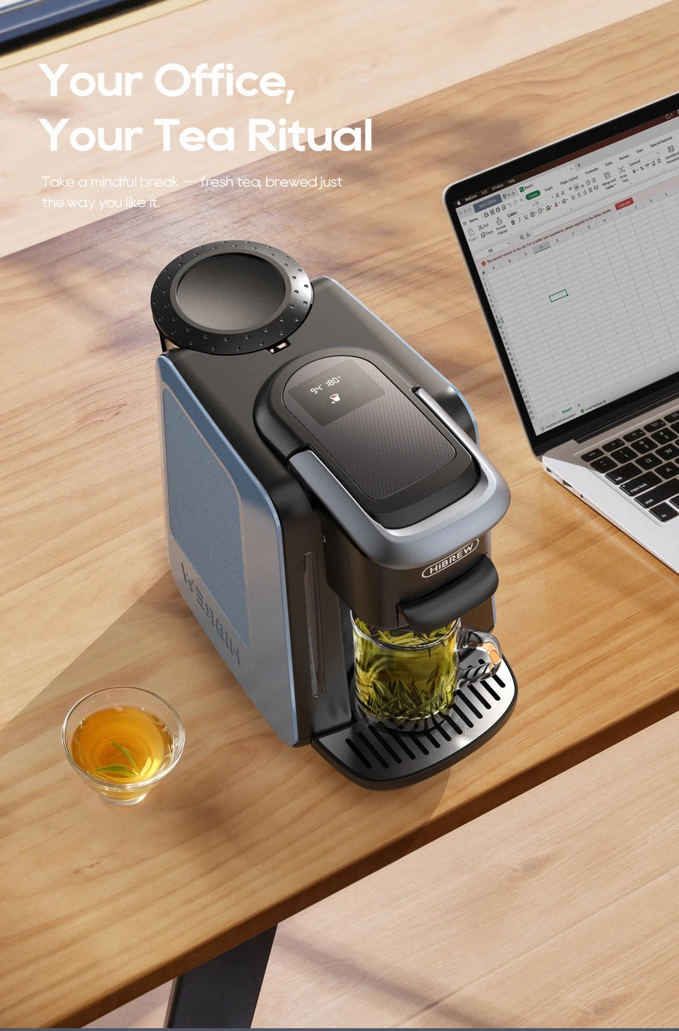 HiBREW blue and black compact office tea maker with digital display, brewing fresh tea in a glass cup on desk.