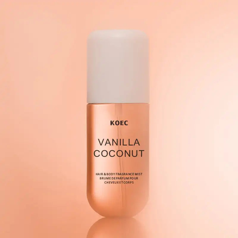 Vanilla Coconut hair and body fragrance mist in a cylindrical rose-gold bottle with a white cap.