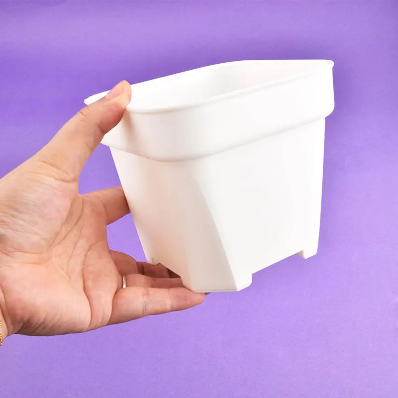 White square planter pot with thick sides, held in hand