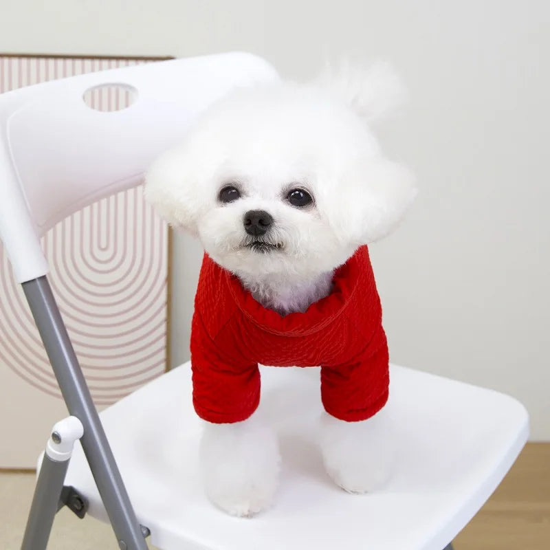 Small white dog wearing a warm, red waterproof winter jumpsuit for puppy comfort and protection.