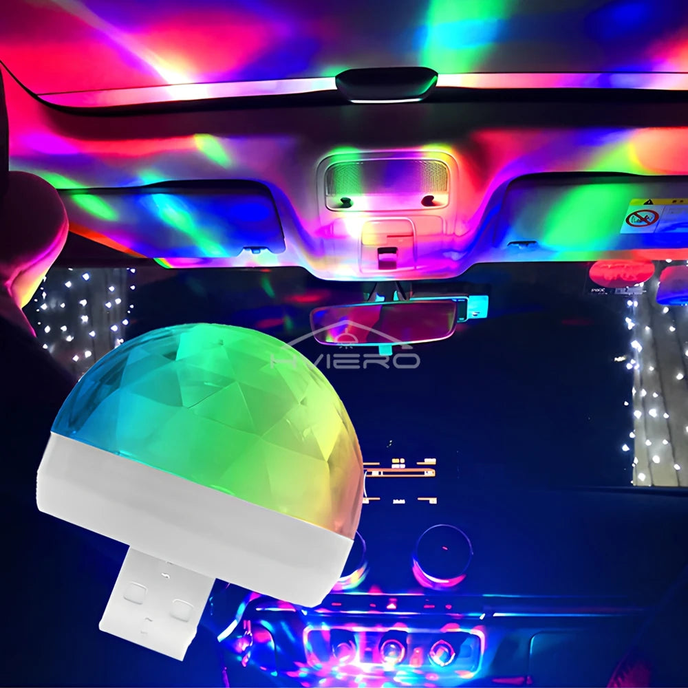 USB disco ball light with a faceted translucent dome, casting multicolored projection patterns inside a car interior.