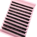 Black individual false eyelash clusters arranged in rows on a pale pink plastic tray for professional makeup