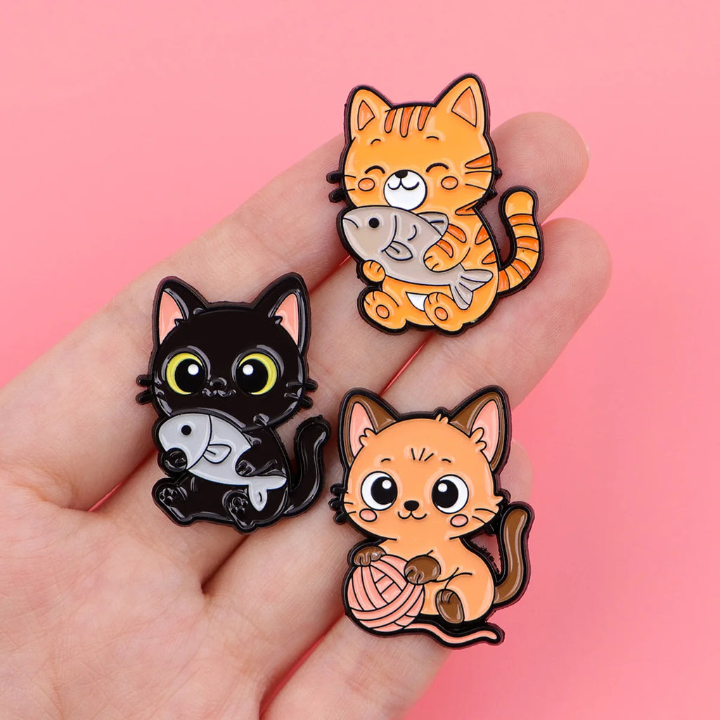 Cute cat enamel pins with fish and yarn, perfect colorful lapel badges for backpacks, accessories, and pet lover gifts.