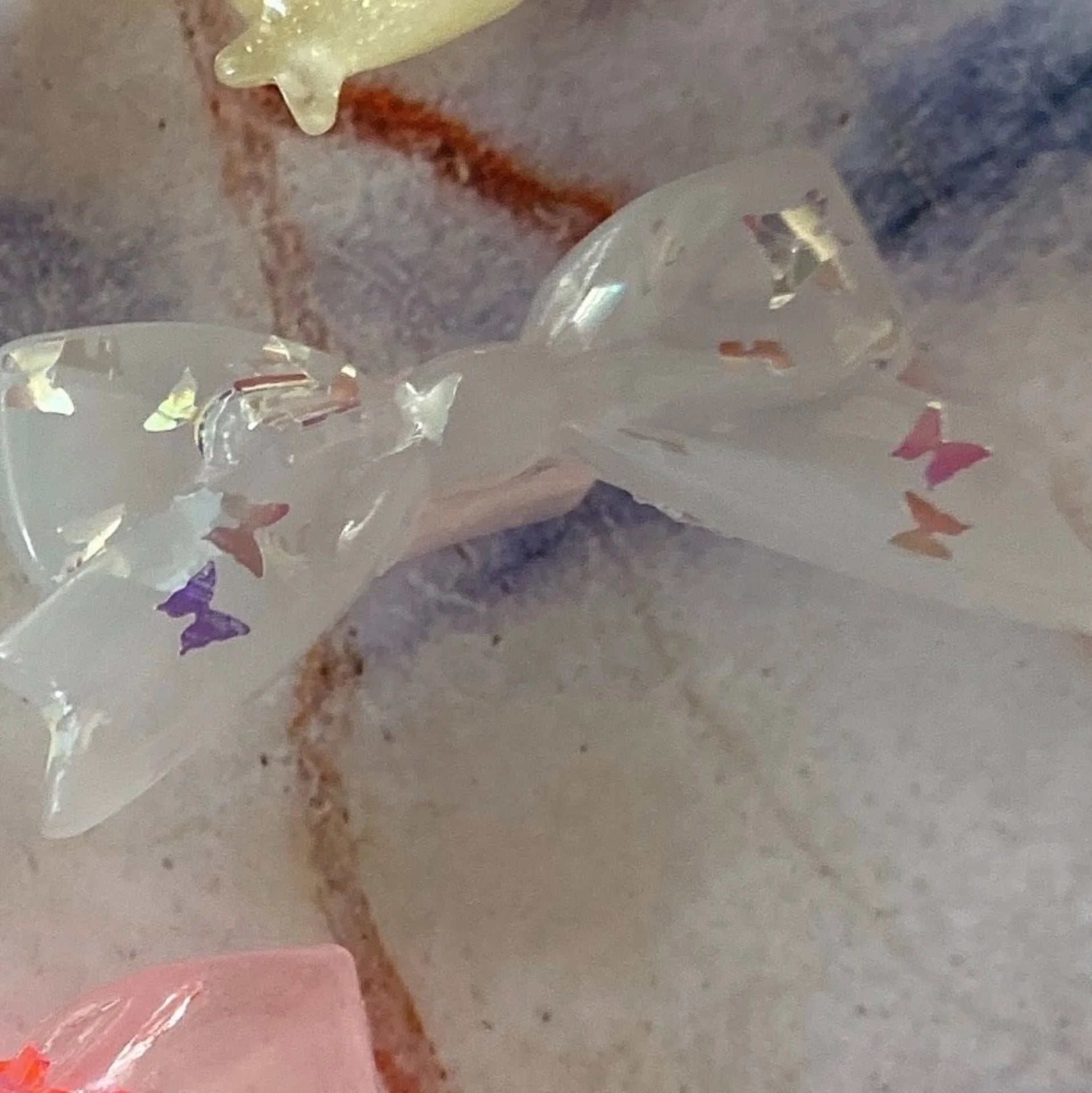 Clear silicone bow dust plug for Tamagotchi Uni, cute butterfly design to protect your electronic pet port from debris.