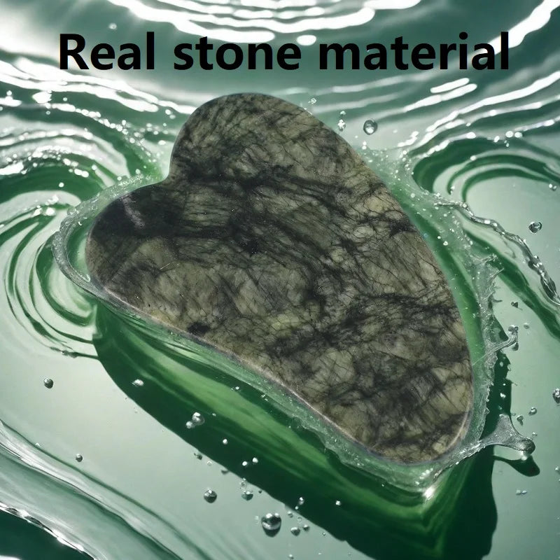 Heart-shaped green marble gua sha facial tool resting in rippling green water.